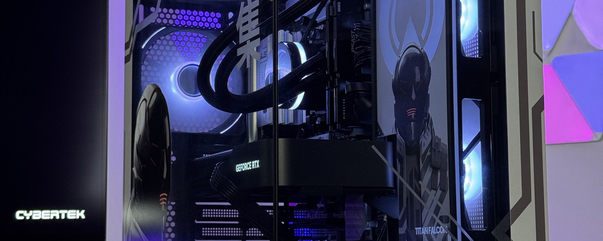 Le boîtier vu de trois quarts, tubes du watercooling et ventilateurs éclairés en bleu derrière le verre, panneaux lumineux violets au mur