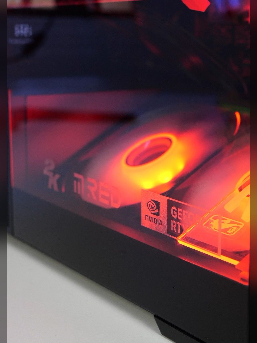 Le bas de caisse vitré, gravé « 2K » et « M.RED », avec la pastille NVIDIA GeForce RTX et deux ventilateurs éclairés